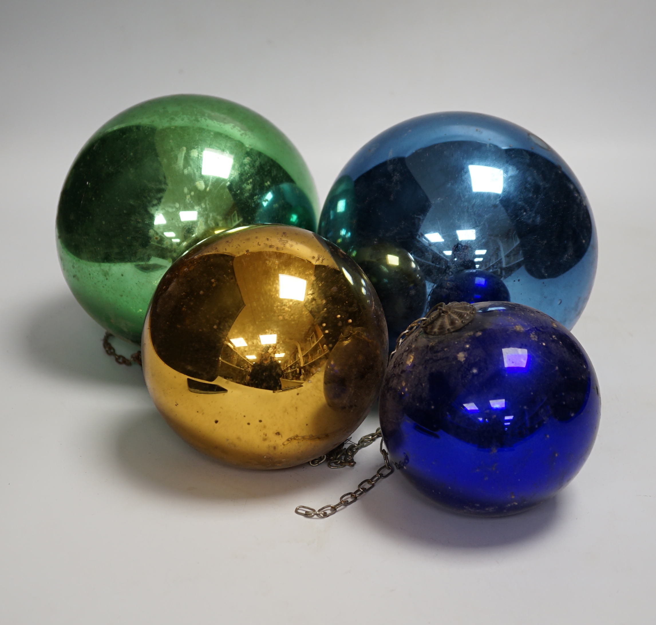 Four various metallic coloured witch’s balls, (dark blue, green, gold and light blue)